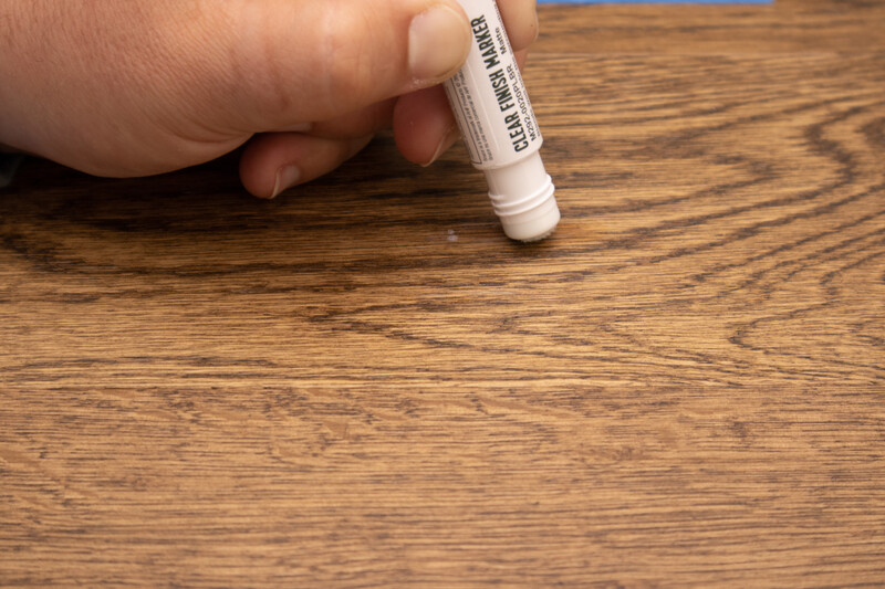 Close up of hand with a touch of pen to care for hardwood floors