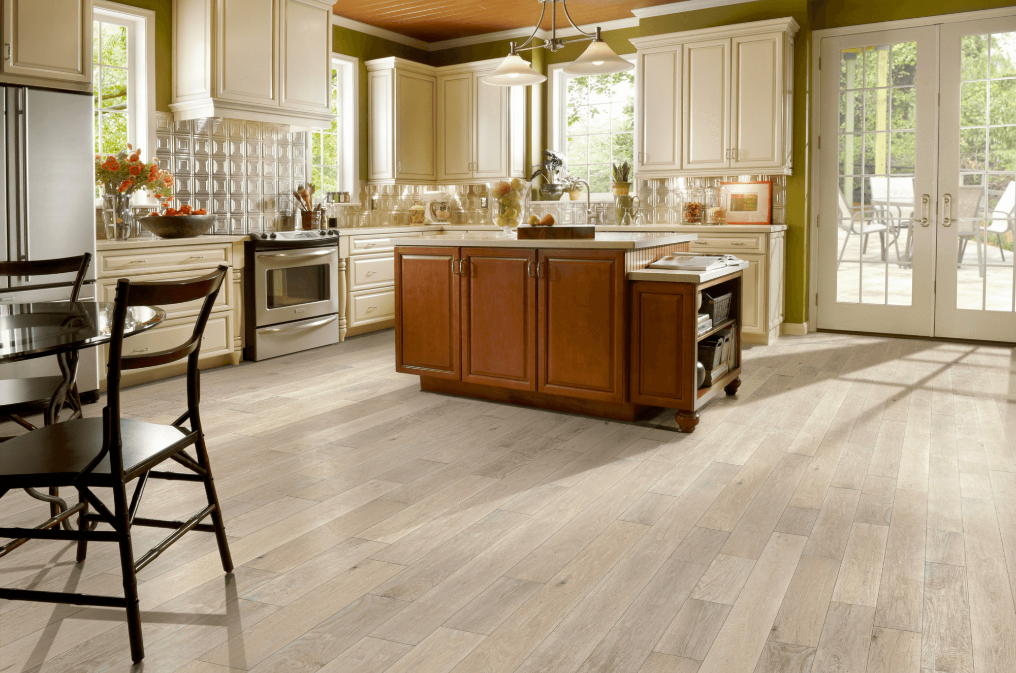 Signature Scrape Oak Solid - Snow Peak Large early American kitchen with an island and French doors overlooking a patio presenting hand-scraped oak hardwood flooring